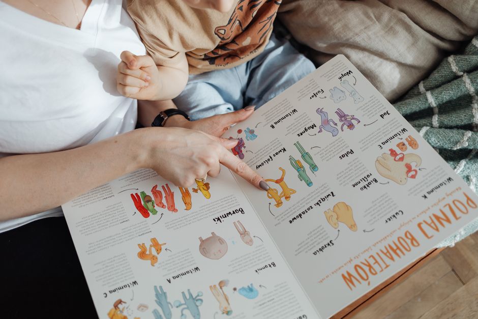 A comforting moment of a mother reading a colorful picture book with her child.